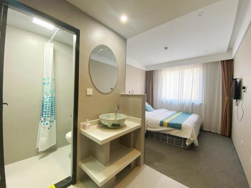 a bathroom with a sink and a bed and a mirror at Beijing RJ Brown City Center Hotel in Beijing