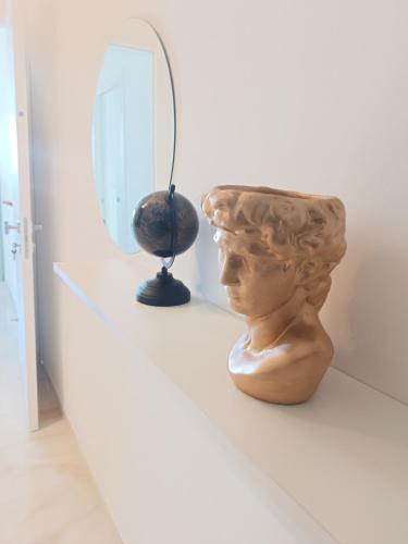 a bust of a head on a shelf next to a mirror at Blumoon boutique in Andria