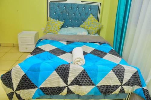een slaapkamer met een blauw bed bij The O,S Homestay in Chuka