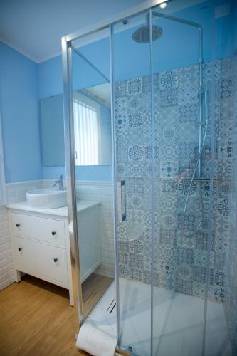a glass shower in a bathroom with a sink at L'Alba dei Pescherecci VISTA CANALE in Chioggia