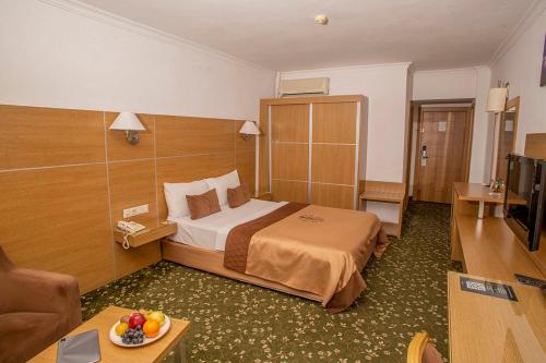 Un pat sau paturi într-o cameră la Grand Cali Hotel