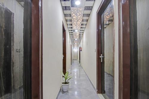 a hallway with a plant in the middle of a building at OYO Flagship 87416 Hotel Moonstar in Ghaziabad