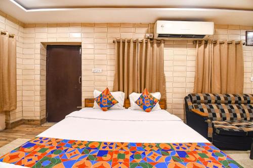 a bedroom with a large bed and a chair at FabExpress Golden Stays in Kolkata
