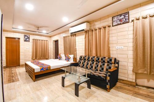 a room with a bed and a couch and a table at FabExpress Golden Stays in Kolkata