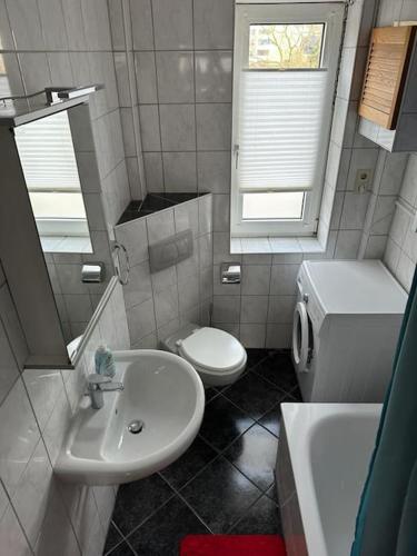 a bathroom with a white toilet and a sink at Wunderschöne Altbauwohnung in Bremerhaven