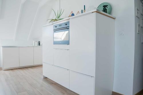 a kitchen with white cabinets and an oven at North Sea's White Shelter - 4 personnes in Koksijde