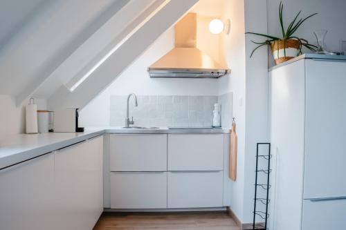 a kitchen with white cabinets and a sink at North Sea's White Shelter - 4 personnes in Koksijde