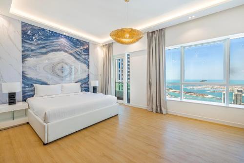 een slaapkamer met een wit bed en een groot raam bij Serene 3BR with Sea View at Marina Pinnacle in Dubai