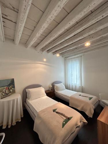 una stanza con due letti e una finestra di Ada Canal House a Chioggia