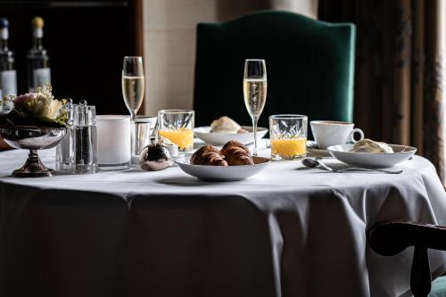 a table with a white table cloth with food and wine glasses at Van der Valk Hotel Kasteel Terworm in Heerlen