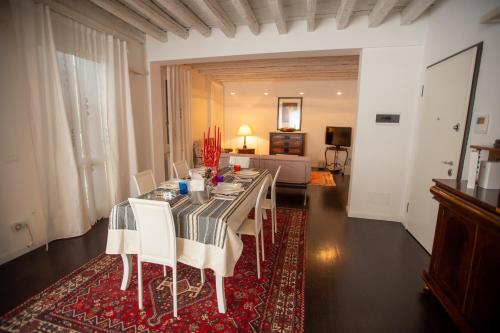 una sala da pranzo con tavolo e sedie e un soggiorno di Ada Canal House a Chioggia
