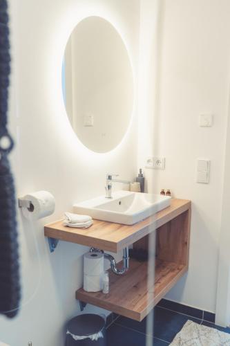 a bathroom with a white sink and a mirror at Anna Pertl - lieblingsquartier in Sankt Gilgen