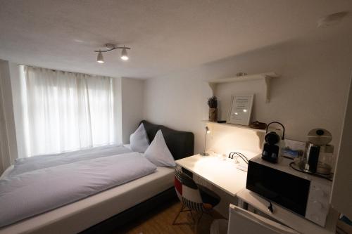 a bedroom with a bed and a desk and a window at Unterkunft "Rathaus" Altstadt, Rheinfelden Schweiz in Rheinfelden