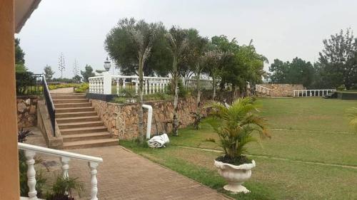 ein Haus mit einer Steinmauer und einer Pflanze im Hof in der Unterkunft Heritage Hotel Rukungiri in Rukungiri