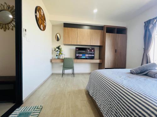 a bedroom with a bed and a table with a chair at HuaHin La Casita condo Quiet, bright room with nice view Netflix vip #2 in Hua Hin