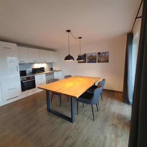 a kitchen with a wooden table and some chairs at Ferienwohnung am Katzberg in Cham
