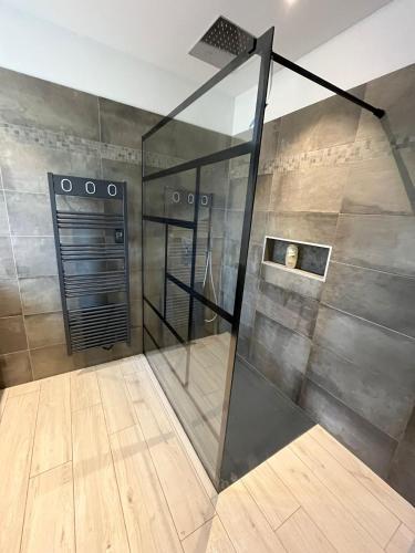 une douche avec une porte vitrée dans une pièce dans l'établissement La FANGADE, à Mirabeau