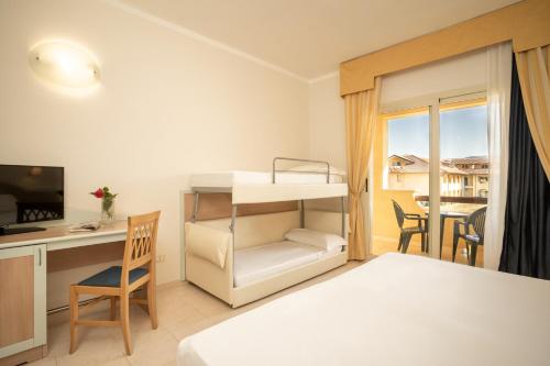 a bedroom with a bed and a desk and a bed at Falkensteiner Club Funimation Garden Calabria in Curinga