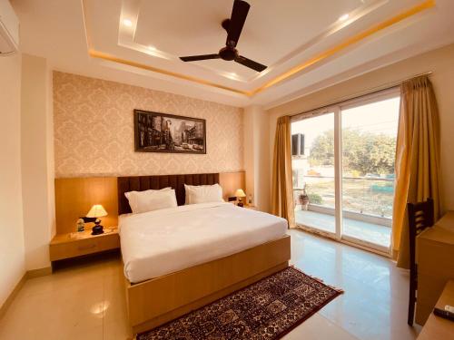 um quarto com uma cama e uma grande janela em Hotel DSR Corporate Suite Sector 45 Gurgaon em Gurgaon