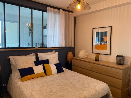 - une chambre avec un lit doté d'oreillers et d'une fenêtre dans l'établissement Splendide vue face à la mer avec garage, à Concarneau