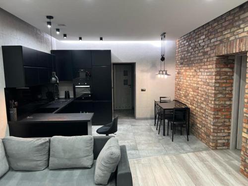 Una sala de estar y cocina con una pared de ladrillo. en Raciborska Royal Apartment - miejsce parkingowe na parkingu strzeżonym, en Gliwice