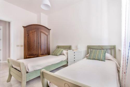 een slaapkamer met 2 bedden en een dressoir. bij Sikelia Luxury Home in Altavilla Milicia