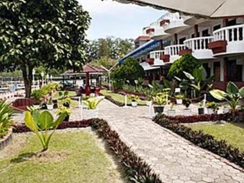 a courtyard of a hotel with a building at Darma Agung Beach Hotel Parapat in Parapat