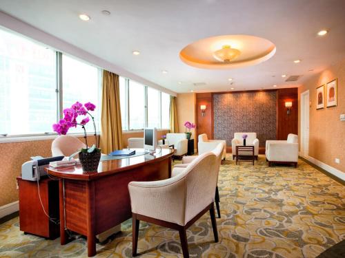 a lobby of a hotel with a desk and chairs at Jiaxing Sunshine Hotel in Jiaxing