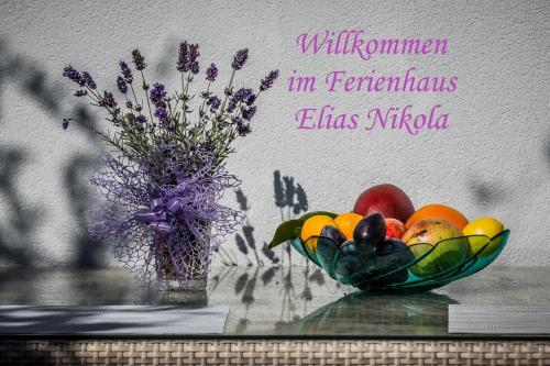 een fruitschaal en een vaas met bloemen op een tafel bij Ferienhaus Elias Nikola in Kaštela