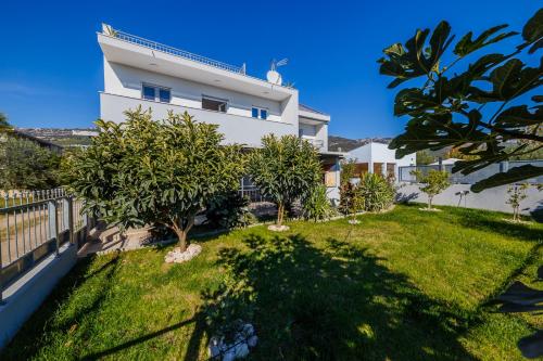 een groot wit huis met bomen in de tuin bij Ferienhaus Elias Nikola in Kaštela