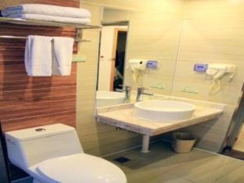 a bathroom with a white toilet and a sink at Yulin Jintone Hotel Wenhua Square Branch in Yulin