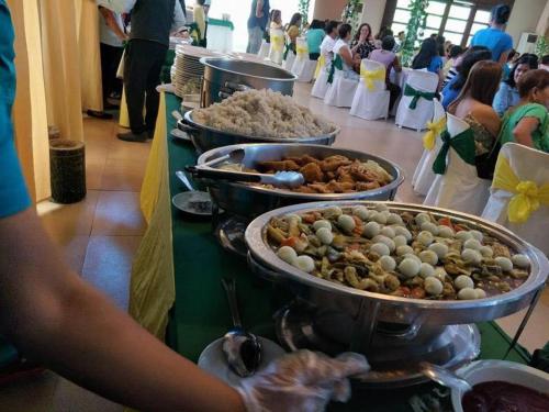 - un buffet avec de nombreuses assiettes de nourriture sur une table dans l'établissement Quezon Premier Hotel - Candelaria, à Candelaria