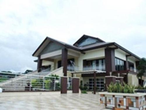 una casa grande con una escalera delante de ella en Quezon Premier Hotel - Candelaria, en Candelaria