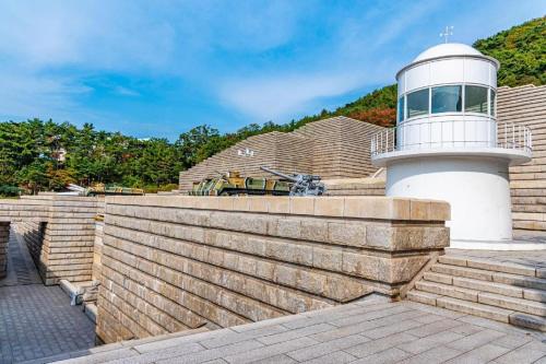 a lighthouse on top of a retaining wall next to a building at Hotel Travel in Incheon