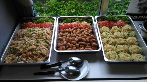 three trays of different types of food on a counter at A+ Hotel in Ubon Ratchathani