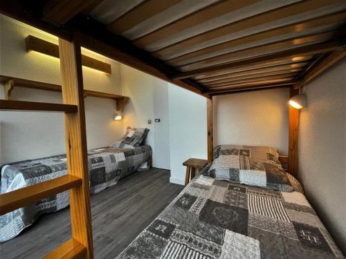 deux lits dans une chambre avec plafonds en bois dans l'établissement Résidence Chaviere - Appartement traversant pour 5 personnes MAE-4984, aux Menuires