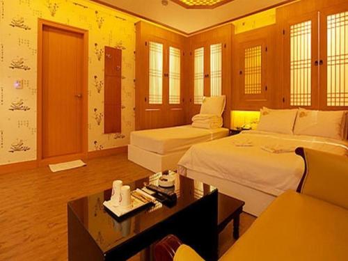 a hotel room with two beds and a table at Hotel Vole Cheonan in Cheonan