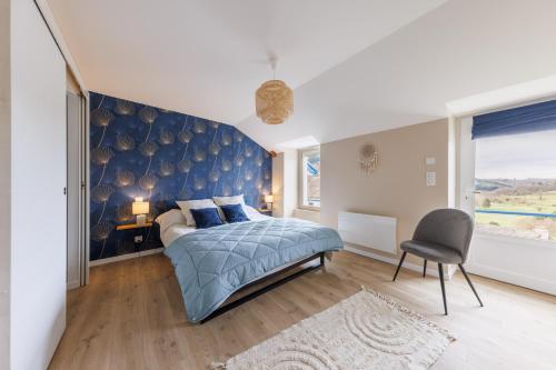 Carladez - 3 chambres et vue montagne في Vezac: غرفة نوم بسرير وجدار ازرق