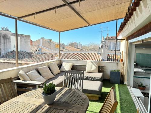 un patio avec une table et des chaises sur un balcon dans l'établissement Le Singulier, à Aix-en-Provence