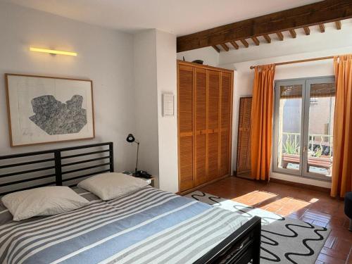 une chambre avec un lit et une grande fenêtre dans l'établissement Le Singulier, à Aix-en-Provence