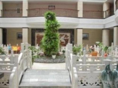 una scala in una stanza con sedie bianche e una pianta di Dali Dayu Hotel a Dali