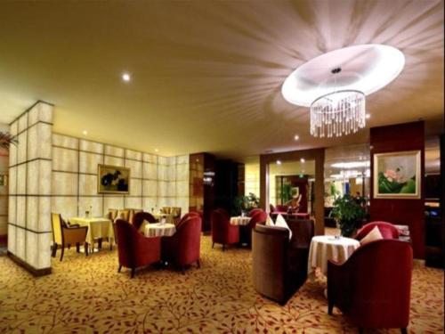 SupoqiaoにあるChengdu Yinsheng International Hotelのテーブルと椅子、シャンデリアのあるレストラン