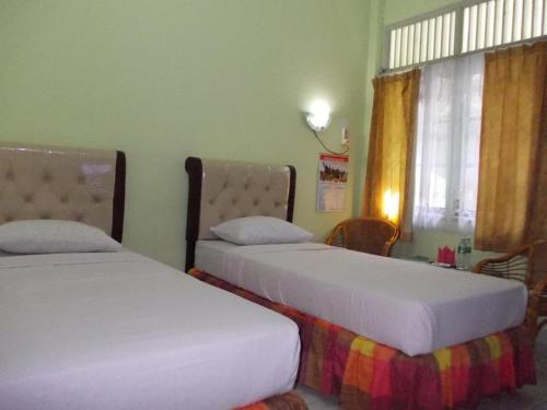 Habitación con 2 camas y ventana en Hotel Bintang en Kampungdurian