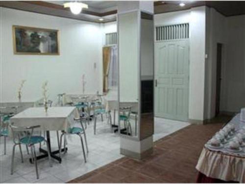 a room with a table and chairs and a room with tables at Hotel Bintang in Kampungdurian