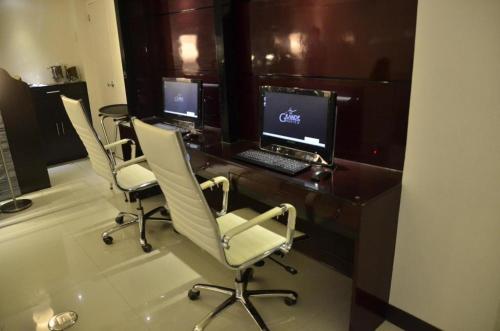 ein Büro mit 3 Stühlen und einem Schreibtisch mit einem Computer in der Unterkunft The Grande Suites in Surigao