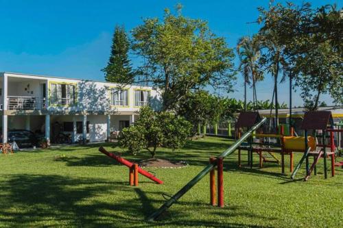 a playground in front of a house with a building at Hotel Campestre Cafetal - Quindio - EJE CAFETERO in Chorro Seco