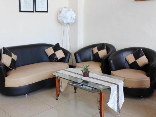 two leather chairs and a coffee table in a room at Hotel Dynasty in Tarakan