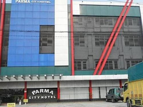 un parking en face d'un grand bâtiment dans l'établissement Parma City Hotel, à Palas 2
