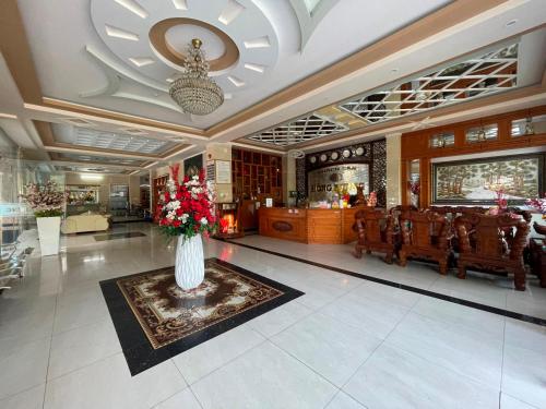 a lobby with a vase of flowers on a rug at Hồng Nhung Hotel Kiên Giang in Rach Gia