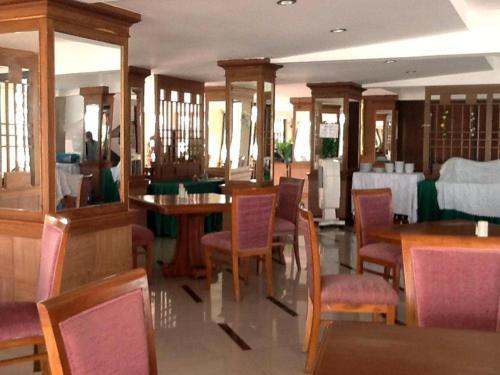 jadalnia ze stołem, krzesłami, stołem i szezlongiem w obiekcie PC Palace Hotel w mieście Sakon Nakhon